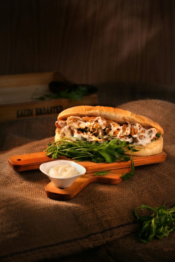 Delicious chicken sandwich with mayonnaise and greens served on a wooden board.